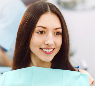 Young brunette girl in a dental chair; for information on gum recession and disease.