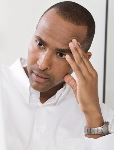African American man portraying concern of a calcified tooth root and root canal treatment