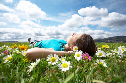 Woman resting in a field of flowers portraying relaxation from sedatiion during a dental deep cleaning